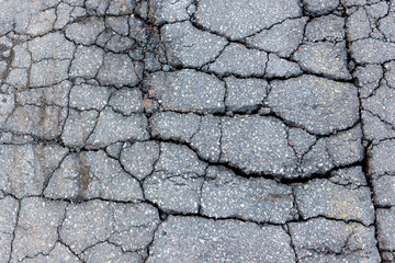Cracked asphalt. A road composed of severely cracked asphalt. Closeup view looking down.