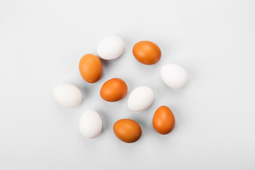 Group of raw eggs white and brown. Concept of diversity, isolation, racism, inequality. On gray background. Top view