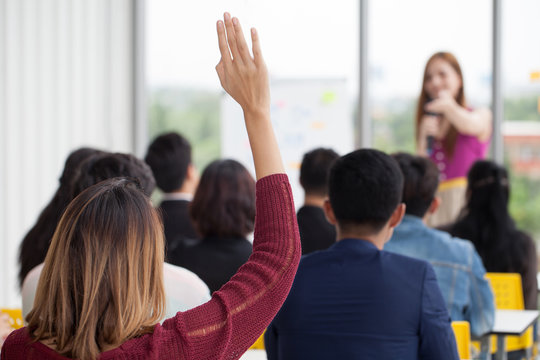 young businesswoman raising hand  to question from Speaker in Seminar. Group Meeting . Conference  Concept . Rear back view