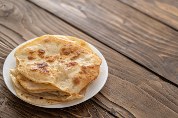 on a plate are fried bread cakes, wooden textured table. with free text, copy space,