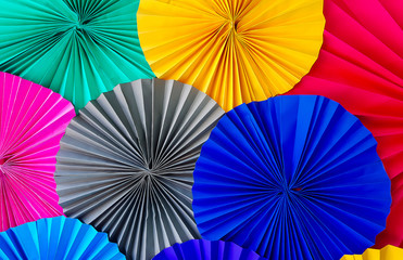 close up of colorful origami paper with different shades arranged in fan shape. concept of colorful paper flowers abstract background