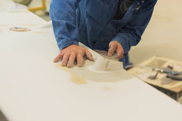 Man aligns sandpaper wing. Worker polishes the working surface