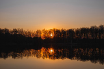 Sunset on the lake. There is a forest in the distance
