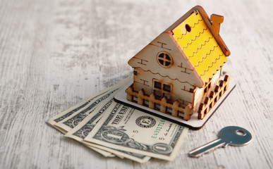  house, keys and dollars on a wooden table