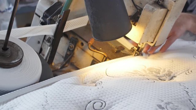 Sewing side tape to mattress. Close up on aged sewing machine