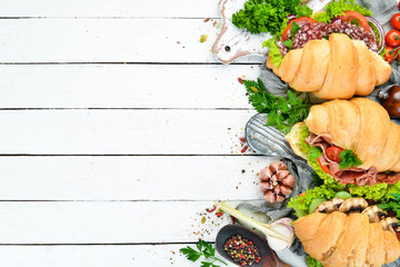 Sandwich croissants with meat, fish and vegetables. Top view. Free space for your text.