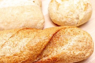 Assortment, different kind of wheat baked bread with golden crust on the table