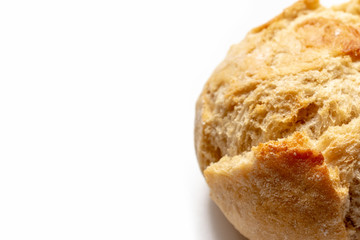 Cropped baked wheat bun with golden crust on white background with copy space, bakery and grocery concept