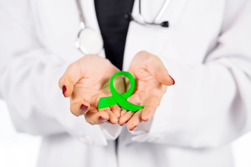Female doctor hands show a lime green ribbon