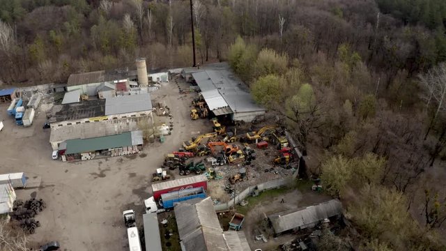 Aerial of heavy machinery junkyard. 4k drone diggers