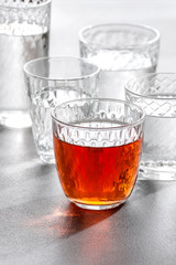 Glass glasses with water and drinks on a gray stone background..