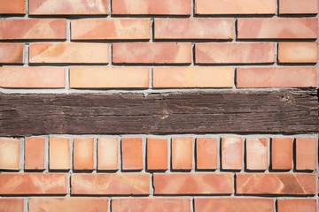 Fototapeta premium Light orange brick background with rustic brown wooden board