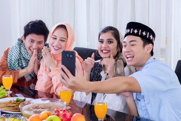 Muslim people take photo together before eating