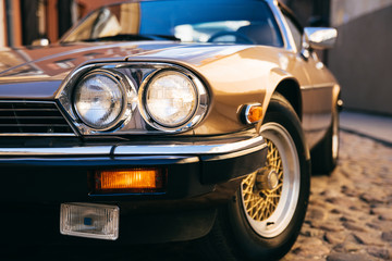 Close up of classic retro car turned on headlamp