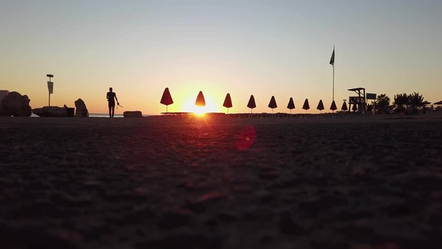 The photographer goes to the beach to shoot a beautiful evening sunset. Beach umbrellas and bottom view. Sand and plug in the background. Cyprus. Pathos