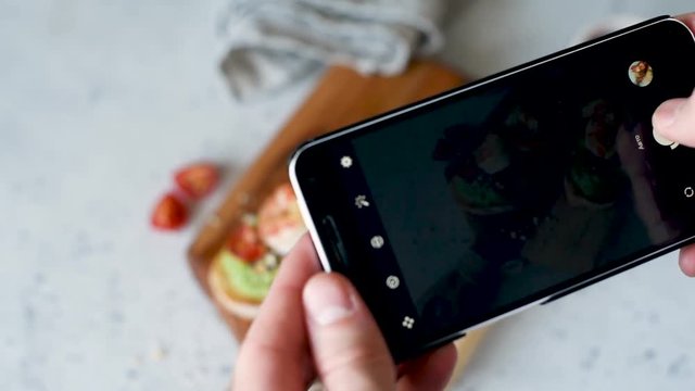 Taking Photos Of Healthy Avocado Shrimp Bruschetta. Mobile Food Photography Concept.
