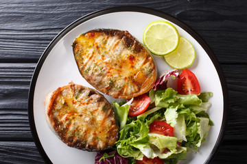 grilled sturgeon steaks with vegetable salad closeup on a plate. horizontal top view