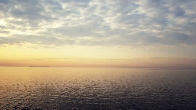Colorful amazing dramatic sky with clouds at sunrise over river surface. Springtime. Video panorama, 4k