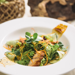 salad with eel and cucumber on a white plate