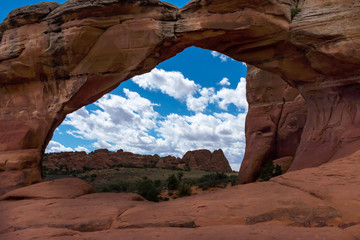 A view of Double Arch at Arches National Park, Utah, USA, bright blue sky, fluffy white clouds and no people in the shot