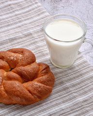 Sweet pretzel and glass of milk on a striped serviette. Delicious snack. Rustic. Space for a text.