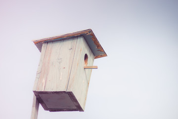 Obraz na płótnie Canvas Blue wooden homemade birdhouse on the sky background