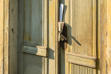 The postman delivered a newspaper and a letter. In the old door there is a letter and a newspaper.