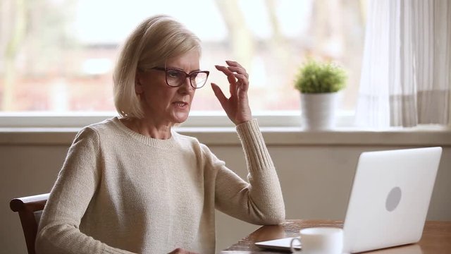 Stressed senior businesswoman annoyed with stuck laptop or system failure