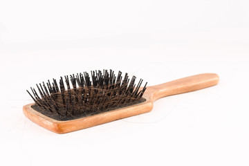 Comb with loose hair in it on a white table. closeup shot