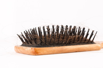 Comb with loose hair in it on a white table. closeup shot