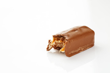 Bitten chocolate bar on a white, closeup
