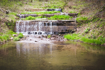 Fototapeta na wymiar Refreshing summer mountain waterfall background