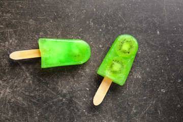 Tasty kiwi ice cream on grunge background
