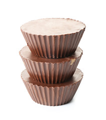 Tasty chocolate peanut butter cups on white background