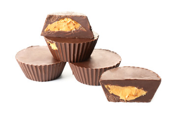 Tasty chocolate peanut butter cups on white background