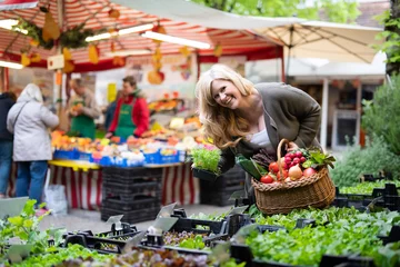 Foto op Plexiglas Freudig lachende Frau kauft auf dem Markt ein  © Wellnhofer Designs