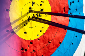 Close up on three arrows in the middle center of the target goal achieved success archery