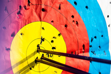Close up on three arrows in the middle center of the target goal achieved success archery