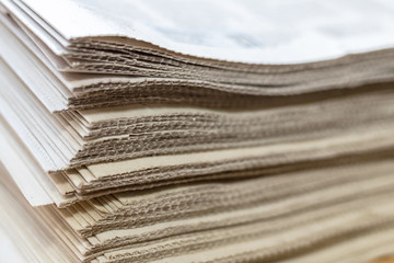 A stack of newspapers close-up. Lots of jagged paper sheets.