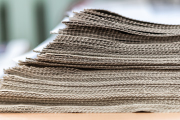 A stack of newspapers close-up. Lots of jagged paper sheets.