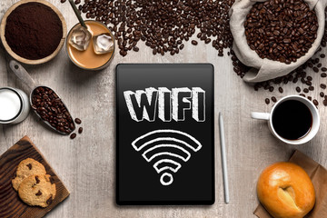 Overhead view of smart computer tablet at coffee shop, wifi internet sign print text signage