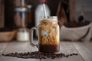 Delicious lifestyle stylized organic homemade ice coffee mocha latte with paper straw and coffee...