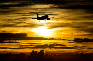 Fototapeta na wymiar AIrplane approaching at sunset