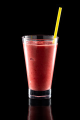 Glass of fresh cold smoothies with straw isolated on black