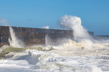 Waves crashing over a jetty, at Newhaven in Sussex