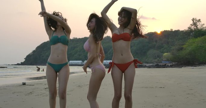 Slow motion of silhouette group of young people dancing at beach party on sunset. People with party celebration concept.