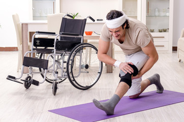 Injured young man doing exercises at home 