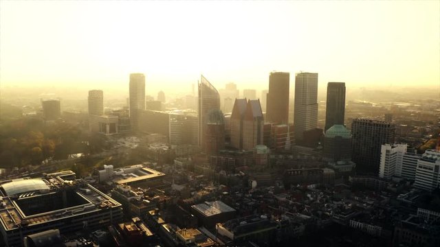 Glowing Den Haag in an aerial shot. The skyscrapers can be seen in front of the rising sun.