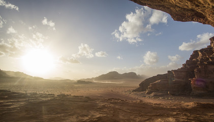 Fototapeta na wymiar Amazing sunset at the Jordanian desert of Wadi Rum ,this breathtaking sunset will really blow your mind. Its stunning to see how the sun disappearing slowly behind those iconic mountains.