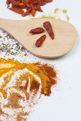 FIRST PLANE OF WOODEN SPOON WITH RED CHILIS AND VARIED SPICES